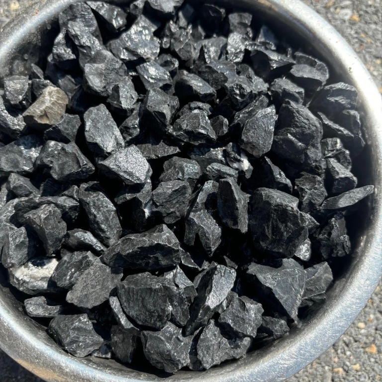 Bowl of shiny black charcoal pieces