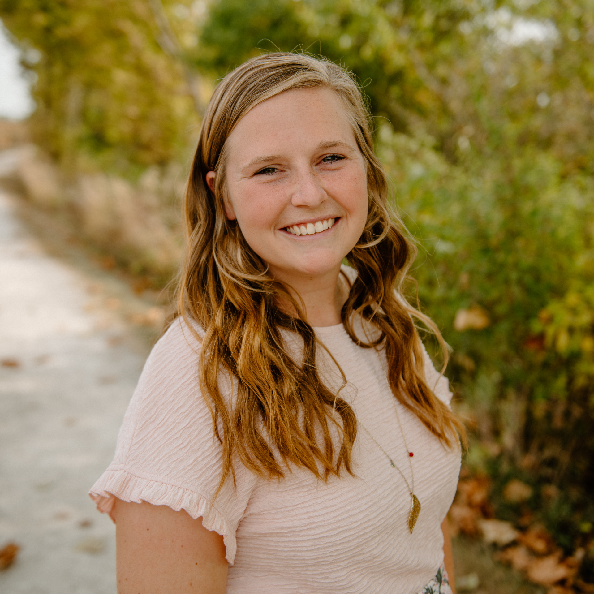 Smiling woman outdoors with trees background