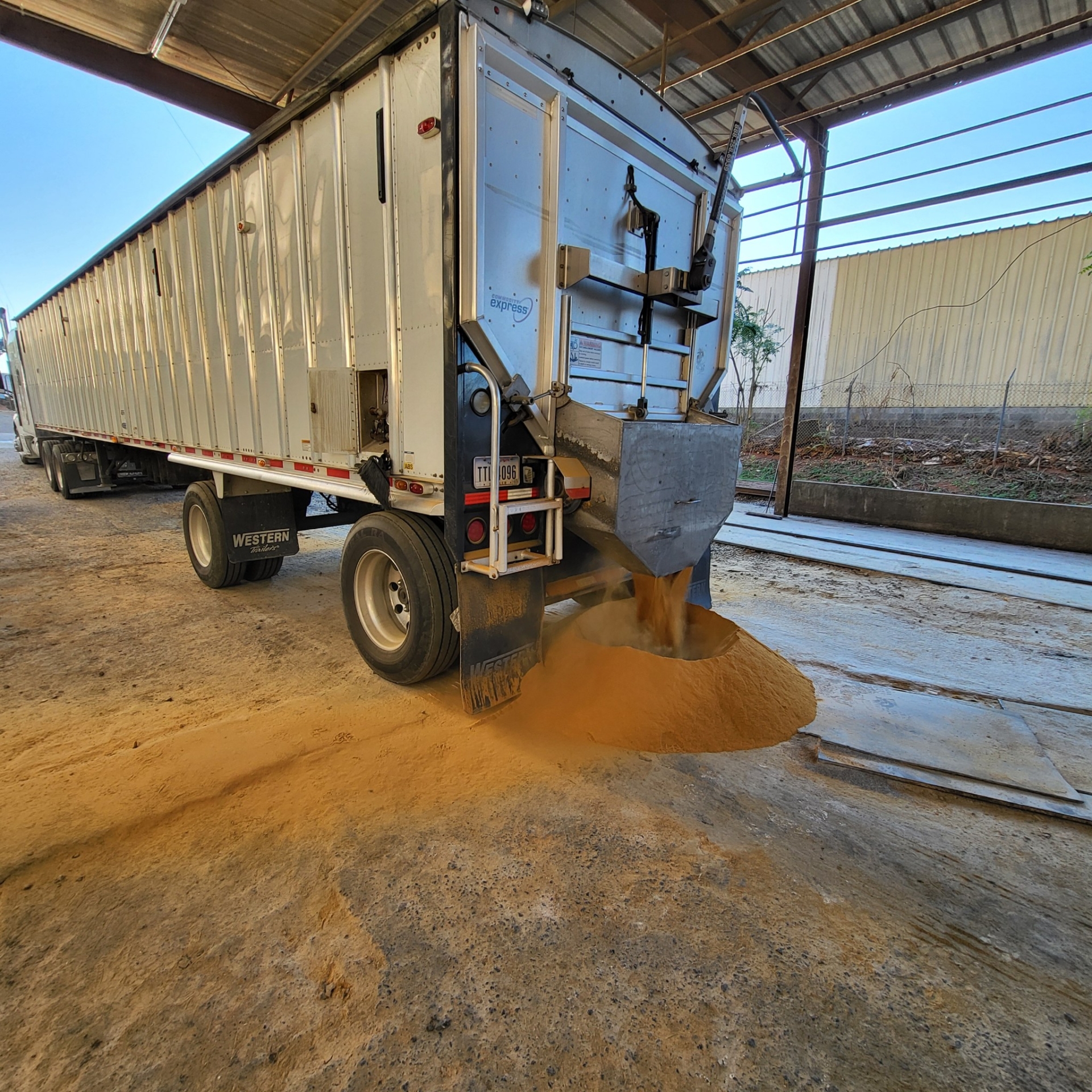 Dump truck unloading sand onto ground.