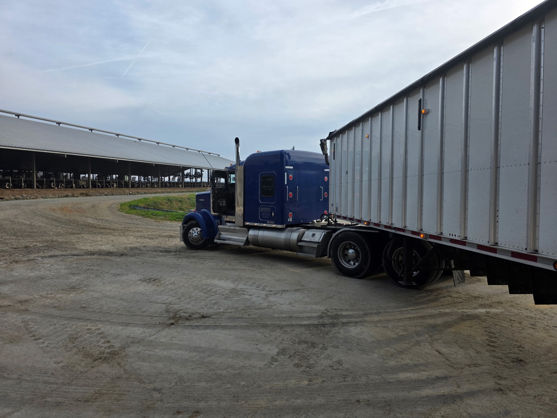 Blue truck parked near farm buildings