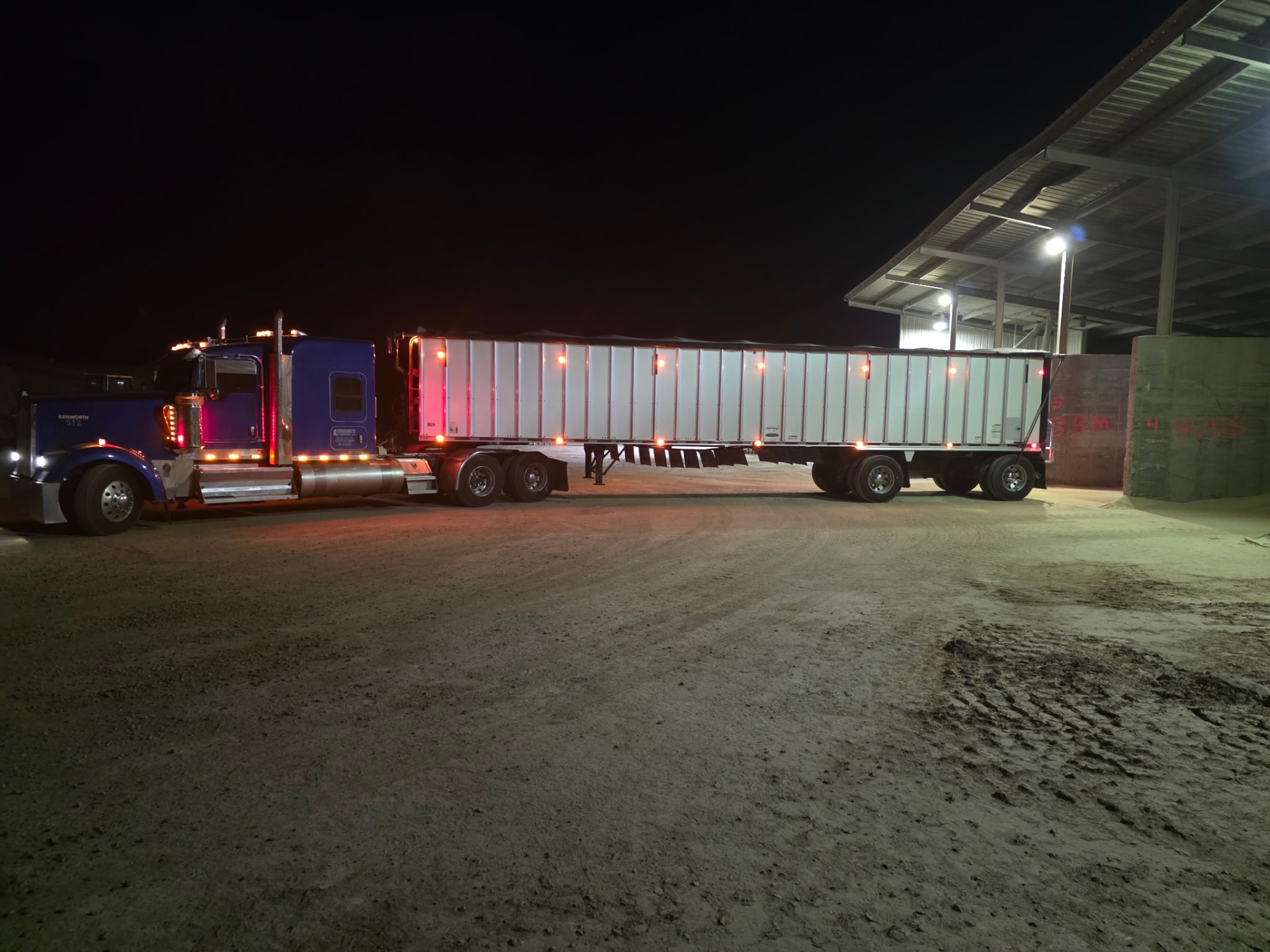Nighttime truck with trailer at a loading dock.